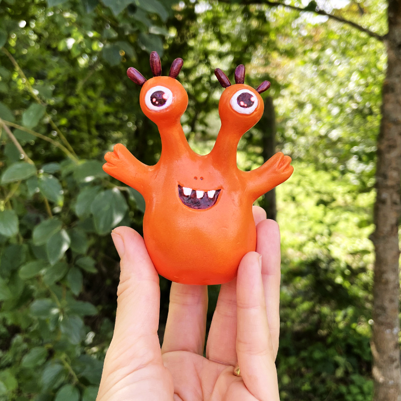 orange monster toy held in hand